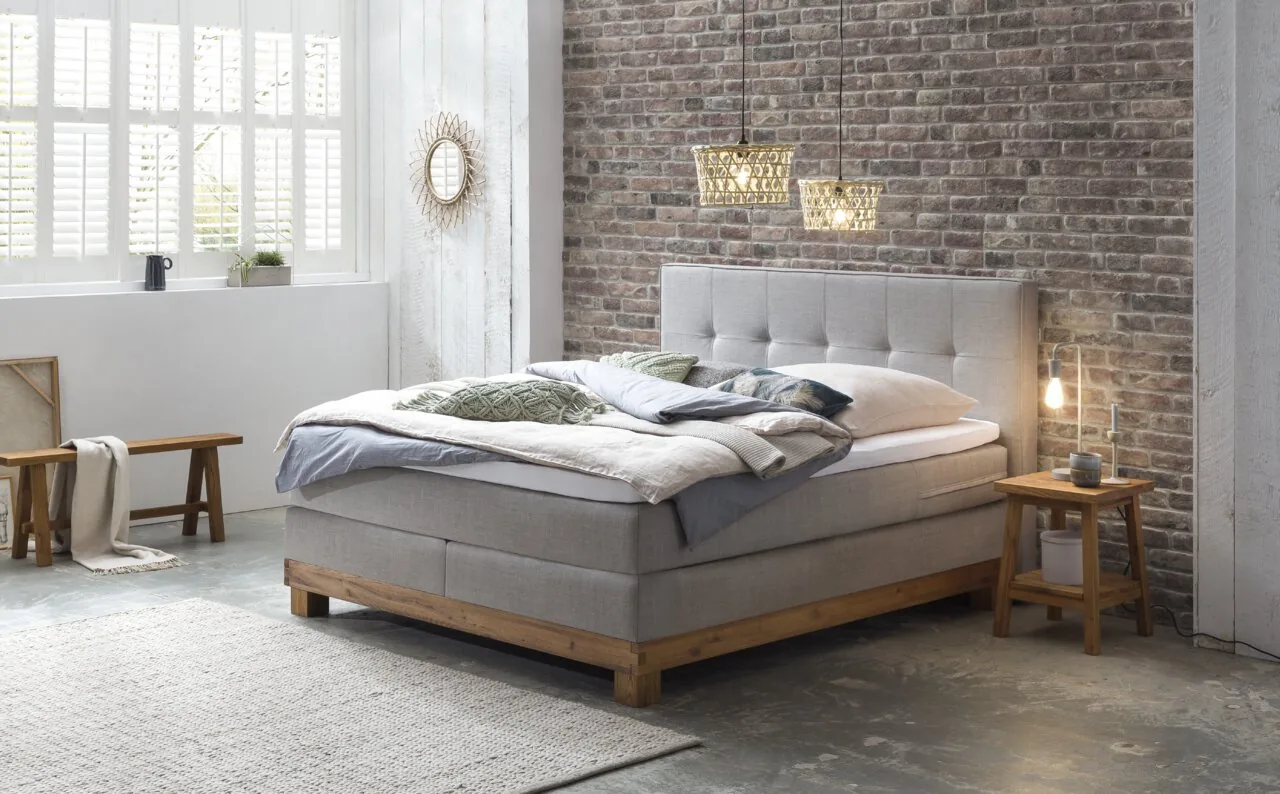 Boxspringbett vor Backsteinwand
