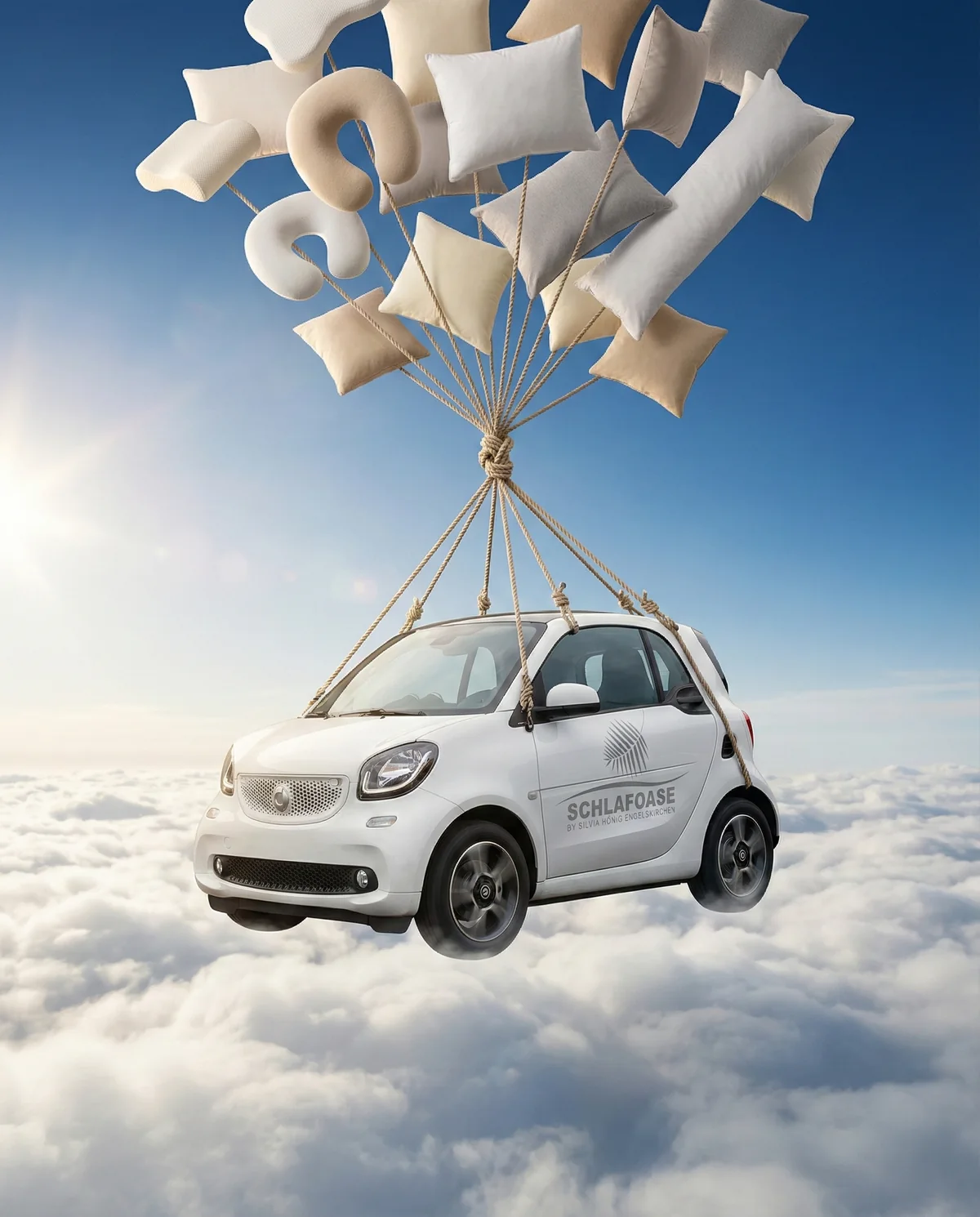 Der SchlafOase-Kissentaxi schwebt an einem Fallschirm aus Kissen über den Wolken